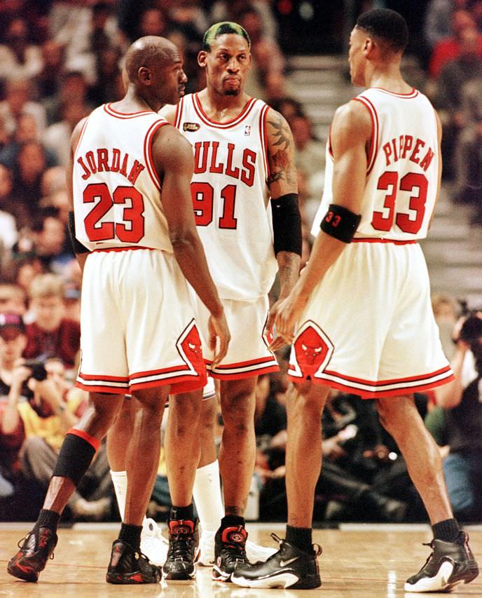 CHICAGO, UNITED STATES: Dennis Rodman of the Chicago Bulls (C) talks to teammates Michael Jordan (L) and Scottie Pippen (L) 10 June during game four of the NBA Finals against the Utah Jazz at the United Center in Chicago, IL. Rodman hit four foul shots down the stretch to lead the Bulls as they beat the Jazz 86-82 to lead the best-of-seven series 3-1. AFP PHOTO/Jeff HAYNES (Photo credit should read JEFF HAYNES/AFP/Getty Images)