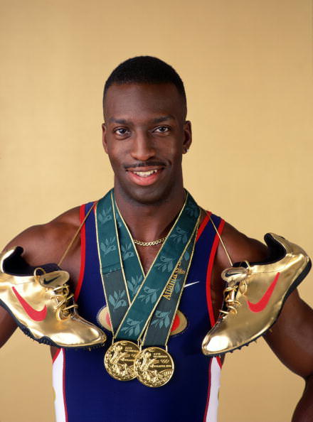 12 Aug 1996: Sprinter Michael Johnson poses for a studio portrait with his two Olympic gold medals and his golden running shoes. Johnson became the first man to complete the Olympic "Golden Double" after winning both the 200m and 400m finals at the 1996C