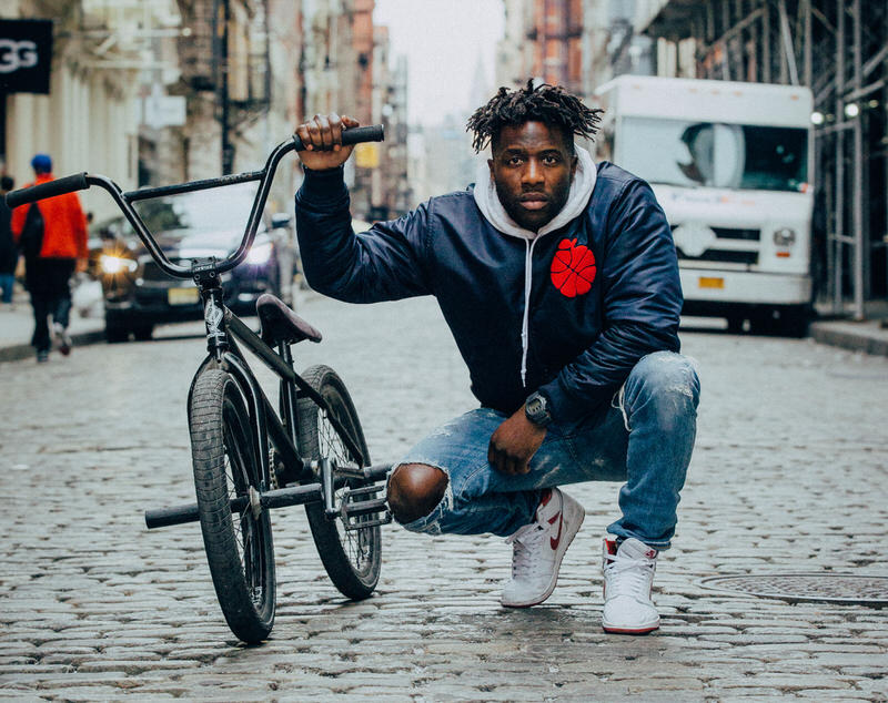 Aime Leon Dore bomber with the red Metallic Jordan 1s.