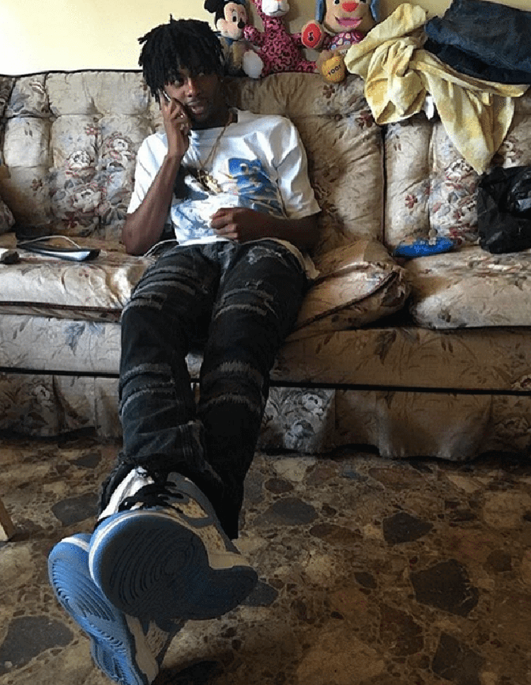 Playboi Carti takes a simple approach by teaming the Supreme x Nike SB Dunk High with thrashed jeans and a graphic tee.