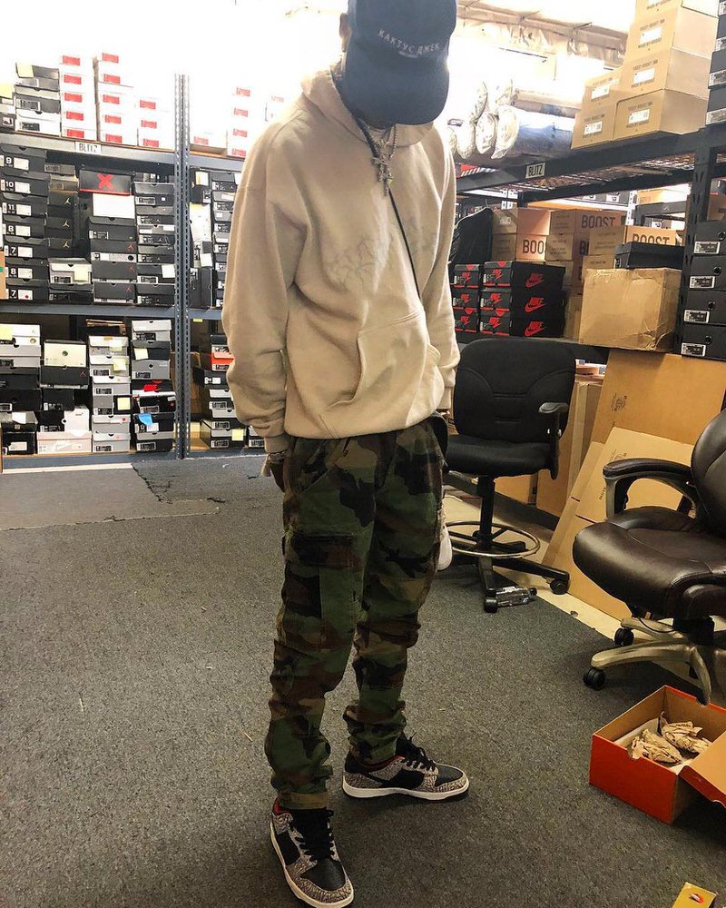 Travis pairs cargo pants with a vintage fitting hoodie and Supreme Dunk Lows.